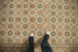 Detailed view of a distressed Qom carpet's floral pattern showing wear to the knot heads.