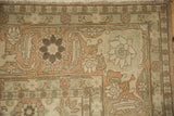 Corner detail of a vintage Qom carpet showing the Turtle Samovar border and worn, low-pile texture.