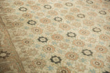 Detailed view of the distressed vintage carpet's worn pile with interconnected floral motifs.