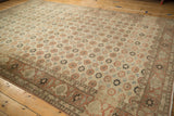 Rows of floral motifs and heavy color abrashes on a vintage distressed Persian Qom carpet.