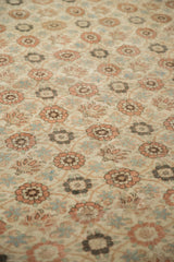 The worn, hand-knotted pile of a vintage Qom carpet showing foundation beneath floral motifs.