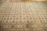 Perspective view of a distressed Qom rug highlighting the heavy abrashes across its allover floral field.