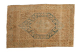 Distressed vintage Sarouk rug with hexagonal dusty blue medallion and faded beige floral motifs.
