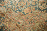 Distressed Kerman rug pile, dusty rose and blue floral arabesques with visible wear.