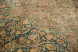 Detailed floral arabesques on a distressed Kerman carpet with dusty blue and warm tones.
