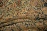 Distressed Kerman carpet pile showing detailed floral arabesques with mostly even wear.