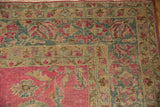 Corner view of an antique Lilihan rug's abrashed magenta field and sand-colored floral borders.