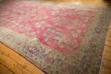 Long perspective of a distressed Persian Lilihan carpet's abrashed raspberry floral field.