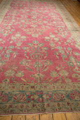 Long view of an antique Lilihan carpet showing its abrashed raspberry field and large-scale floral design.