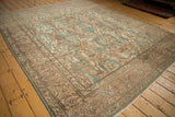 Close-up of distressed vintage Turkish Sparta carpet, dusty teal and sand floral palmettes, arabesque leaves.