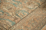 Distressed pile of vintage Sparta rug showing faint foundation, dusty teal, and sand motifs.