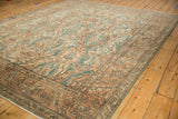 Worn dusty teal and sand arabesque motifs and floral palmettes on the Sparta carpet.