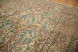 Distressed vintage Sparta carpet texture with dusty teal, sand, and abstract floral motifs.