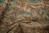 Distressed vintage Sparta carpet, showing wear, dusty teal, and sand stylized patterns.