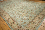 A perspective view of the interconnected floral vines on a powder blue distressed vintage rug.