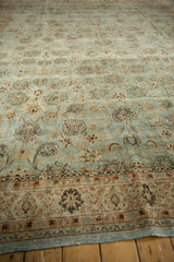 Angled perspective on the distressed, low-pile texture of a vintage Persian carpet's floral field.