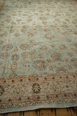 Low angle view across the distressed vintage carpet showing the textured pile and floral motifs.