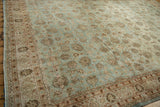 A vintage Persian carpet's distressed texture highlights its powder blue and brown floral design.