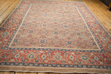 Angled view of the entire antique Northwest Persian carpet, showing its scale and camel Herati field.
