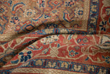 The textured, even wear of a hand-knotted antique Persian carpet in camel, blue, and red tones.