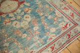 Distressed Lilihan rug corner, cherry red arabesque border, sky blue abrashed field with floral patterns.