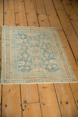 Distressed Hamadan rug corner featuring powder blue floral vines and detailed boteh borders.
