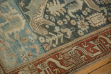 Close-up of a vintage Mehreban rug's rust-colored serpent-like border and dusty blue field.