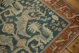 Angled corner of a vintage Mehreban rug with a serpent-like border and sprawling leaves.