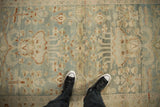 Distressed vintage Hamadan rug, its faded floral motifs in dusty blue and brown.