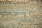 Distressed vintage Hamadan rug featuring dusty blue, ivory, green, and pink floral patterns.