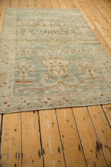 Secured ivory fringe and light blue border of the distressed Hamadan rug, showing mostly even wear.