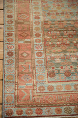 Mostly even wear showing the knot heads and geometric border of a distressed Kurdish rug.