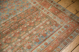 Corner of a vintage Kurdish Hamadan rug with raspberry red motifs and distinct color abrash.