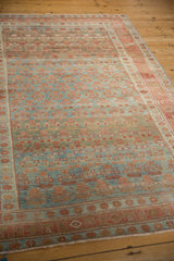 Vintage Kurdish Hamadan rug viewed at an angle, showing the full pattern layout and time-softened texture.
