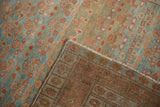 Close-up of a vintage Hamadan rug's folded corner, showing its reverse weave and side cord.