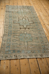 Distressed Karaja runner detail: dusty blue geometric medallion, serrated leaves, mostly even pile wear.