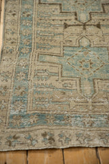 Distressed texture of the Karaja rug's geometric motifs in dusty blue and antique ivory.