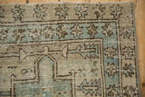 Distressed Karaja rug corner with geometric motif and worn dusty blue, cream pile.