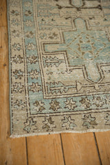 Distressed Karaja rug border with dusty blue, ivory geometric patterns, and starburst florals.
