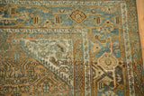 Corner view showing the worn texture and Turtle Samovar border of a vintage Persian rug.