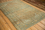 Angled view of the distressed vintage Persian rug with heavy abrashes and time-softened tones.