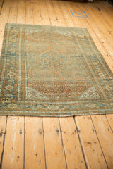 A high-angle perspective showing the full layout of a distressed vintage Persian area rug.