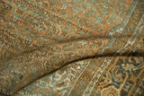 Textured low pile of a distressed Persian rug in copper, dusty blue, and gold tones.