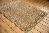 Distressed vintage Bijar rug corner, showing muted terracotta borders and worn Herati field.