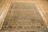 Distressed vintage Bijar rug corner, highlighting terracotta and silver floral border with secured fringe.