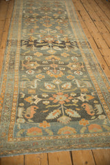 Distressed vintage Persian Lilihan runner in time-softened charcoal and tangerine florals.