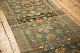 Distressed Lilihan rug with interwoven floral pattern in terracotta, slate blue, and orange.