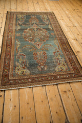Distressed corner of vintage Kurdish Hamadan rug with slate blue ground, rustic floral motifs, and visible wear.