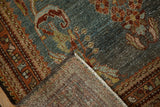 Folded vintage distressed Kurdish Hamadan rug with slate blue abrash, rust patterns, and woven foundation.