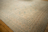 Distressed Ersari rug corner with geometric minor borders in dusty teal and cream.